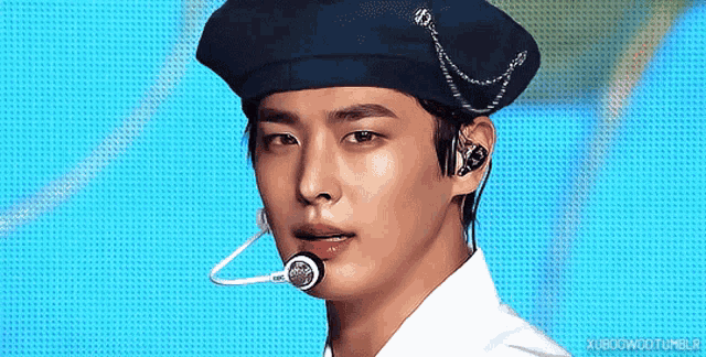 a close up of a man wearing a beret and earphones