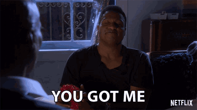 a man in a black shirt is smiling and says you got me netflix
