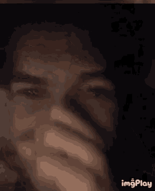 a close up of a person making a funny face with their hands
