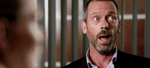 a man with a beard and a suit is making a surprised face .