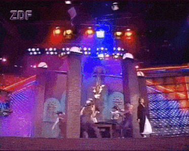 a group of people are dancing on a stage with zdf written on the screen