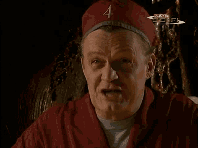 a man wearing a red hat with the letter a on it is sitting in front of a screen that says axn scifi