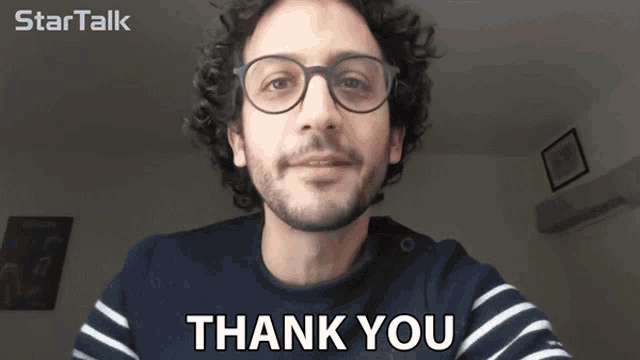 a man with glasses says thank you in front of a startalk logo