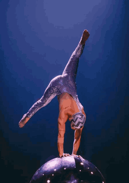 a man is doing a handstand on a ball