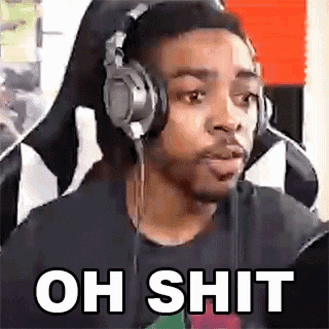 a man wearing headphones is sitting in a chair and making a face .
