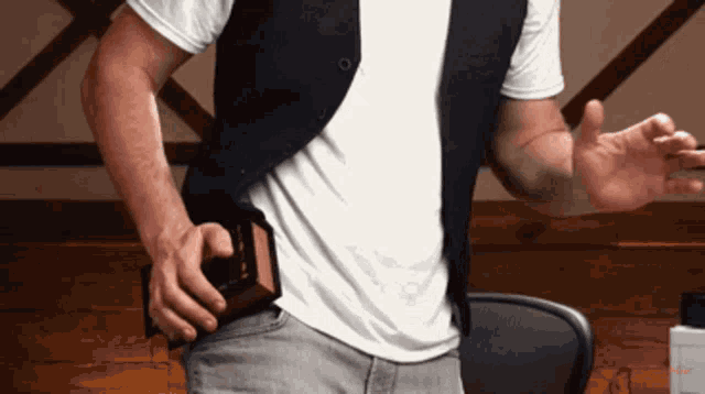 a man wearing a white shirt and a black vest holds a bible