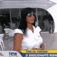 a woman wearing sunglasses and a white shirt is on a television screen .