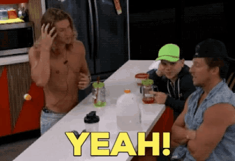 a group of men sitting at a table with the word yeah written in yellow
