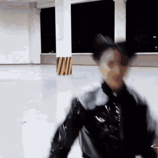 a blurry picture of a person in a black jacket standing in a room