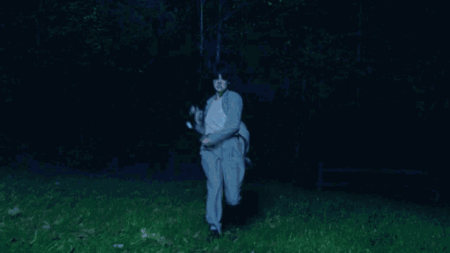 a woman in a suit is holding a flashlight in her hand