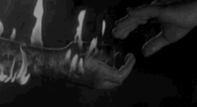 a black and white photo of a person with flames coming out of their mouth .