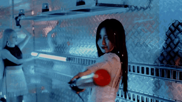 a woman is holding a red ball in her hand