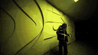a person is standing in front of a yellow wall with a drawing on it