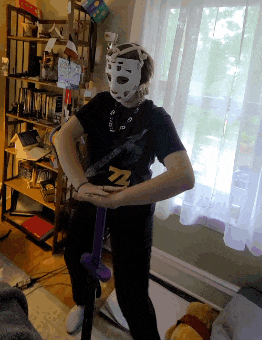 a person wearing a mask and holding a purple sword