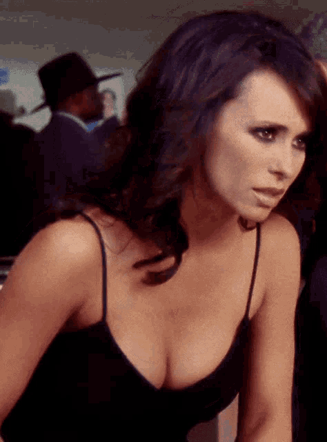 a woman in a black tank top has a very large cleavage
