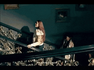 three women are dancing on a stage in a room .
