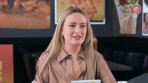 a woman is sitting at a table with a menu in front of her and a sign that says ' chicken ' on it