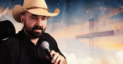 a man in a cowboy hat is holding a microphone