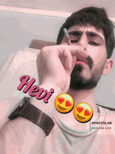 a man is smoking a cigarette with the name hevi on his wrist