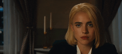 a woman with blonde hair is wearing a black jacket and a white shirt
