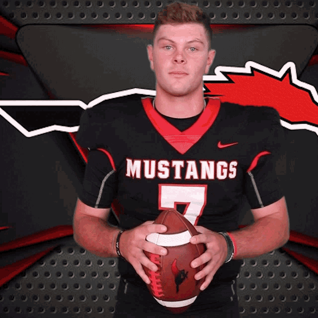 a man in a mustangs jersey holds a football in his hands