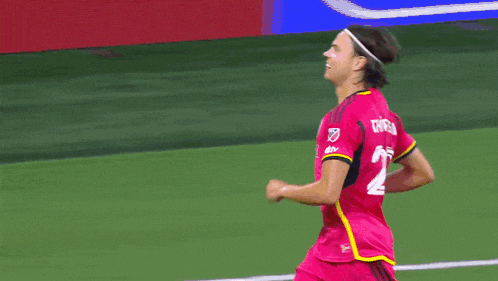 a soccer player wearing a pink shirt with the number 24 on it