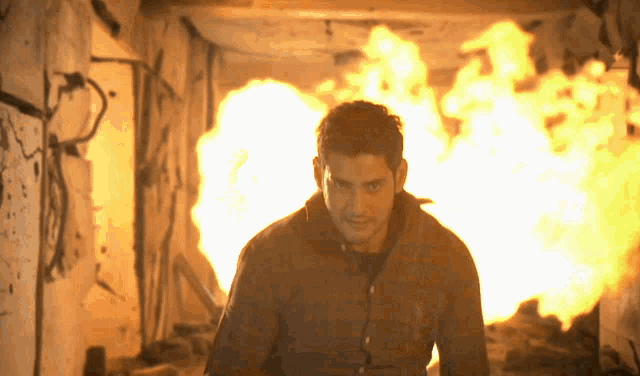 a man is standing in front of a fire in a tunnel