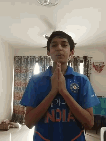 a boy wearing a blue shirt that says india on the front