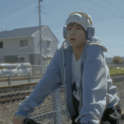 a person wearing headphones and a beanie riding a bike
