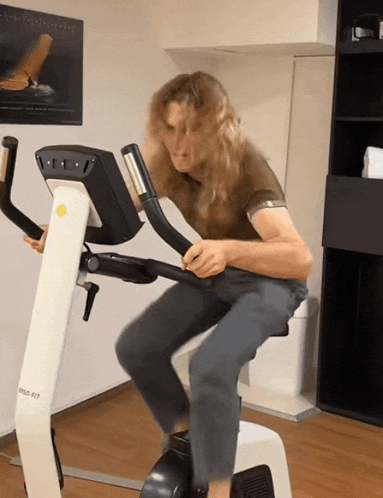 a man is riding an exercise bike with a yellow sticker on it