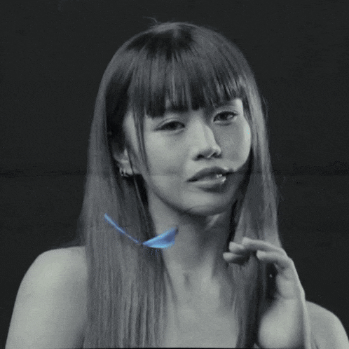 a black and white photo of a woman with a blue butterfly flying in the background