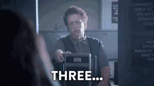 a man is standing in front of a machine that says three on it