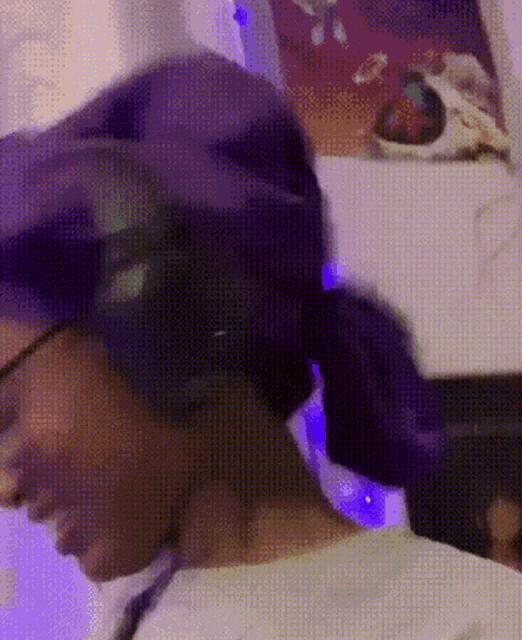a close up of a person wearing a purple hat and glasses .