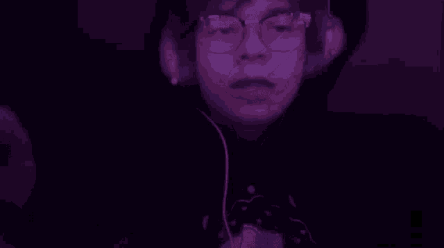 a close up of a person wearing headphones and a hoodie in a dark room .