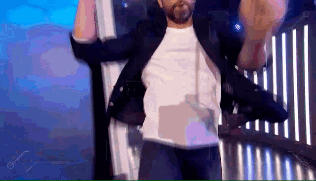 a man in a suit and white shirt is dancing on a stage .