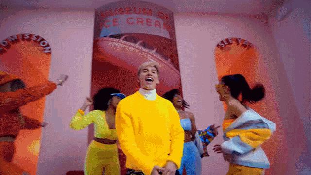 a group of people are dancing in front of a museum of ice cream sign .