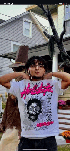 a man standing in front of a house wearing a t-shirt that says ' heavy metal ' on it