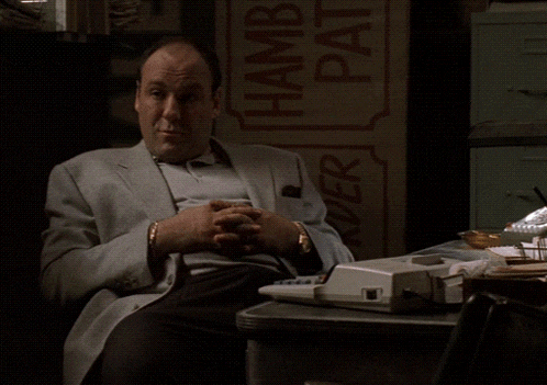 a man in a suit is sitting at a desk with the words buon anima written above him