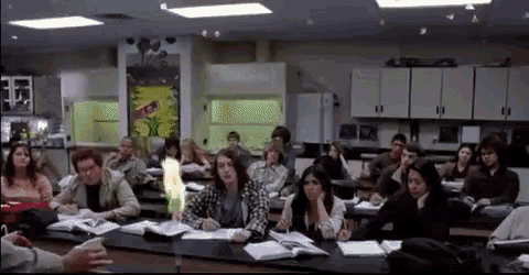 a large group of people are sitting at desks in a classroom ..