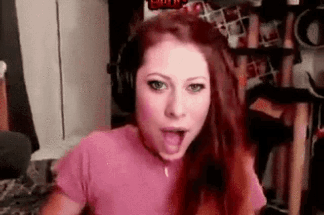 a woman is wearing headphones and making a funny face .