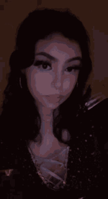 a close up of a woman 's face in a dark room .