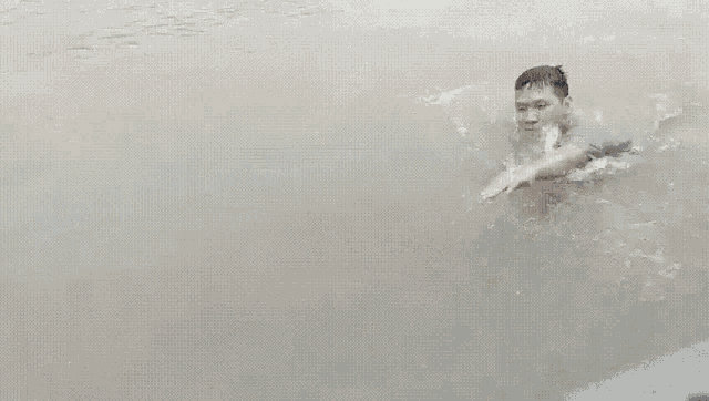 a person swimming in a body of water with their arm outstretched