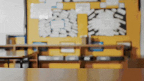 a blurry picture of a classroom with a bulletin board