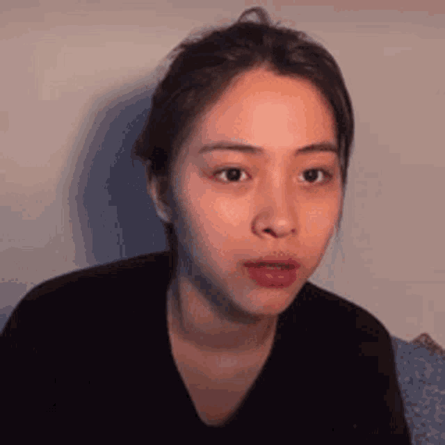 a woman without makeup is making a funny face while sitting on a couch .