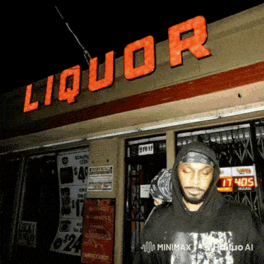 a man in a black hoodie stands in front of a liquor store