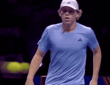 a man wearing a blue adidas shirt and white hat