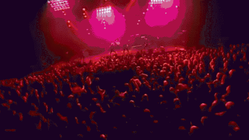 a man is playing a guitar on a stage with red lights .