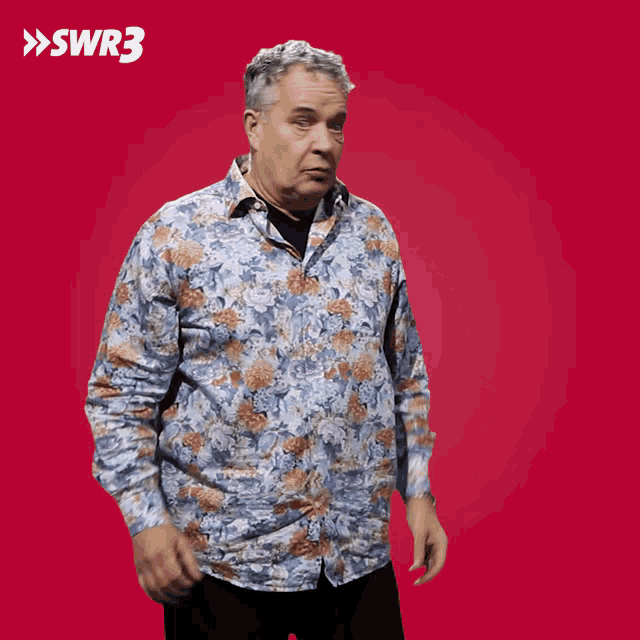 a man in a floral shirt is standing in front of a red background with swr3 on it