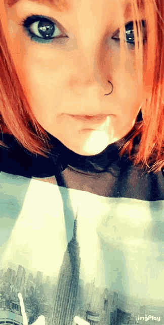 a woman with red hair is wearing a shirt with a picture of new york on it