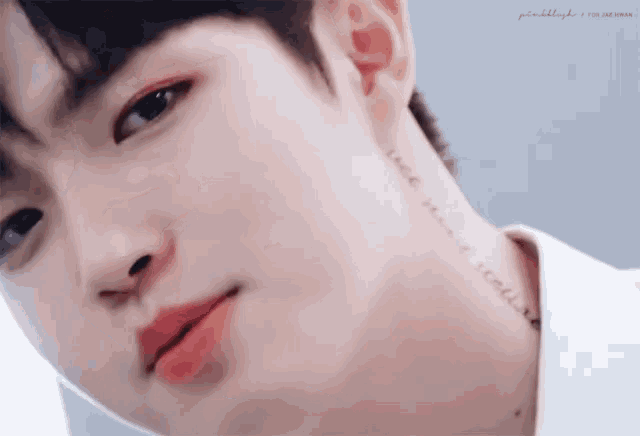 a close up of a young man 's face with a tattoo on his neck that says " i love you "